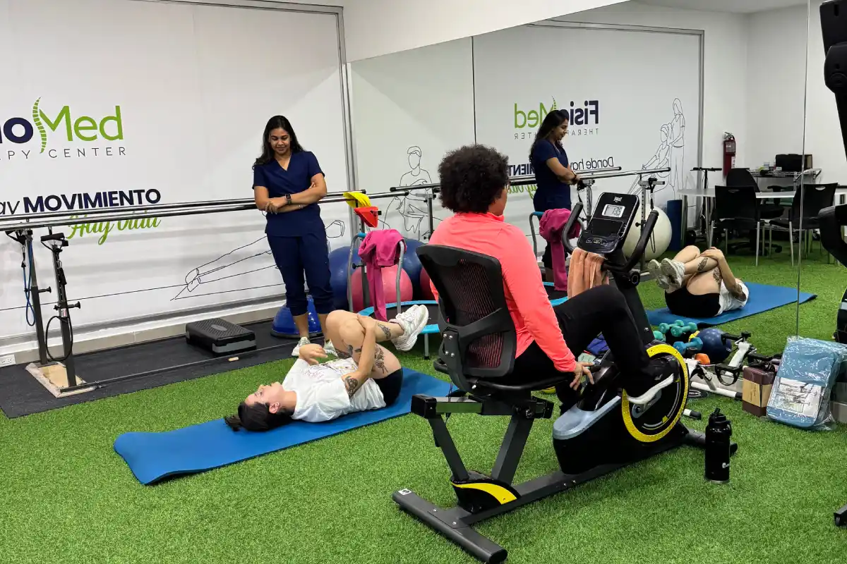 Pacientes realizando ejercicios de rehabilitación supervisados en el gimnasio de FisioMed