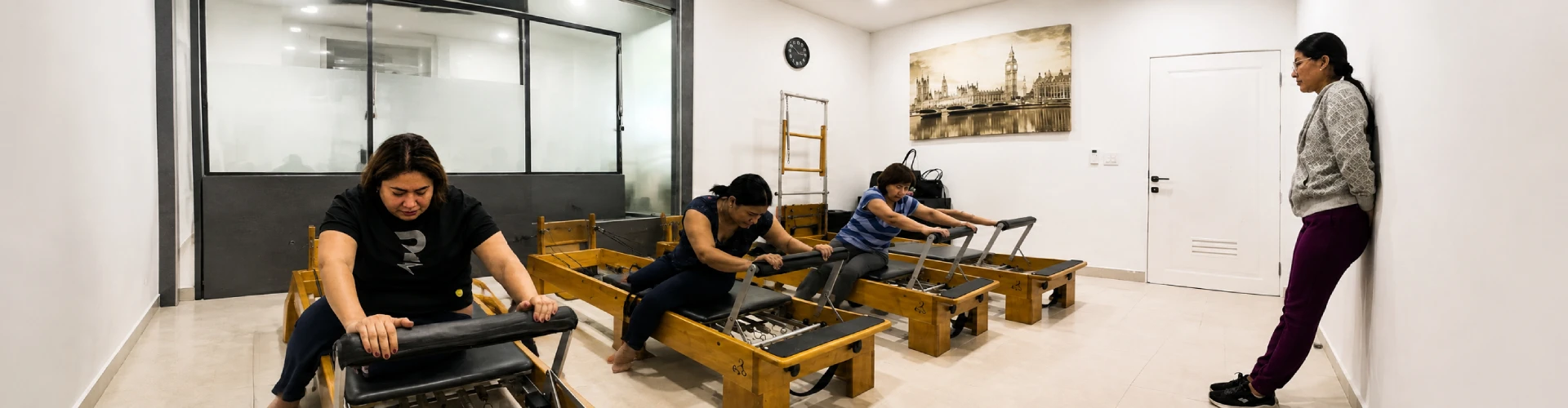 Grupo realizando ejercicios de Pilates Reformer con supervisión de una instructora