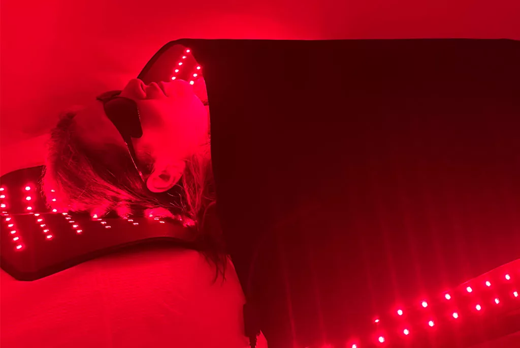 Paciente recibiendo terapia de luz roja bajo paneles luminosos