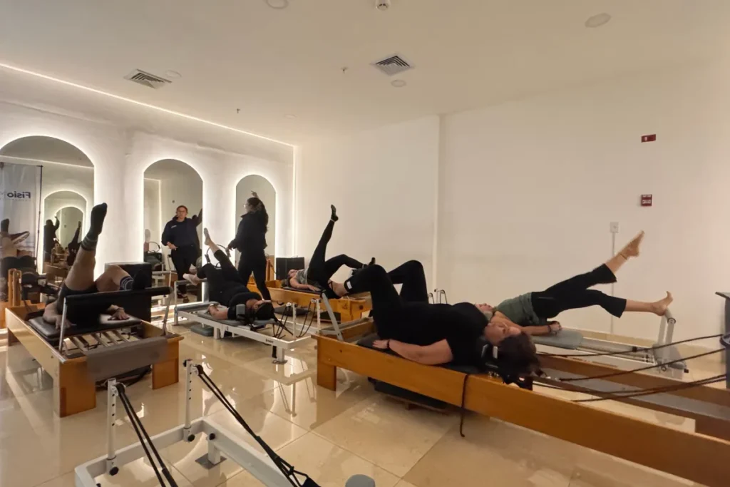 Pacientes realizando ejercicios de fortalecimiento de piernas en Pilates Reformer