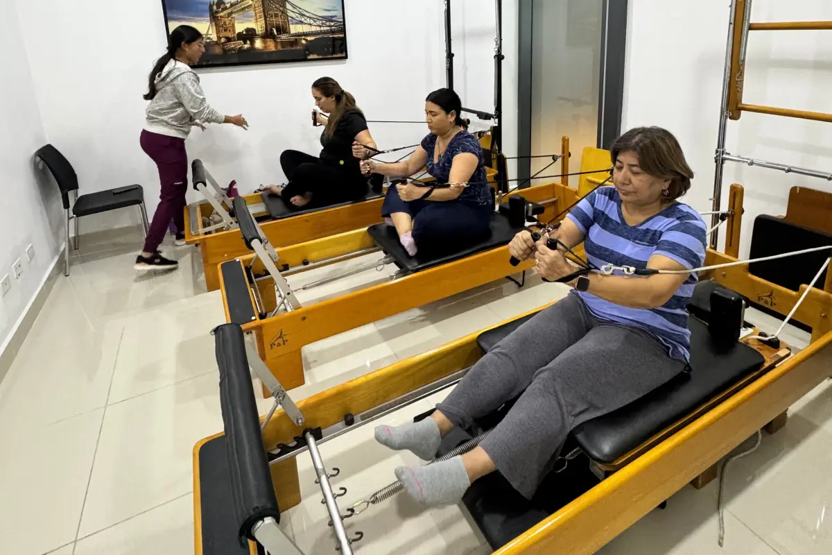 Mujeres realizando ejercicios de Pilates terapéutico en equipos Reformer
