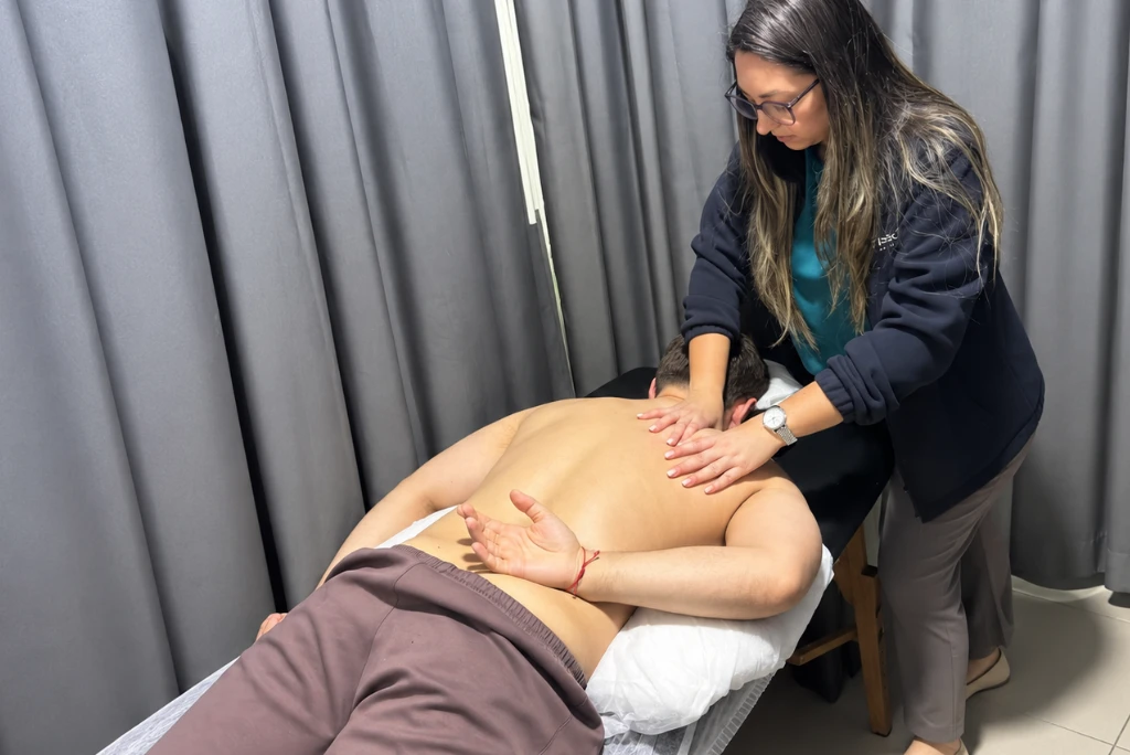 Terapeuta movilizando el antebrazo y el codo de un paciente