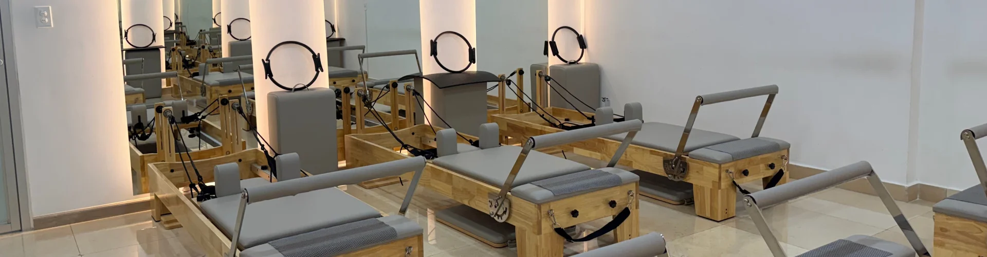 Estudio de pilates terapéutico de FisioMed en Vía Porras, Ciudad de Panamá, con máquinas Reformer y espejos iluminados